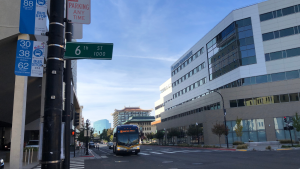 Photo of a bus driving in downtown Sacramento approaching a bus stop